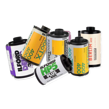 Various rolls of black and white and colour film stacked together.